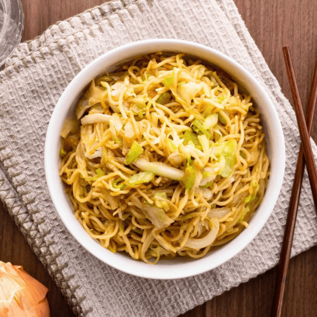 Noodles in white bowl with chop sticks
