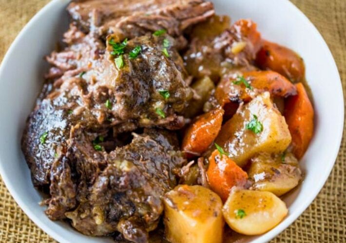 Bowl with portions of cooked roast, potatoes and carrots.