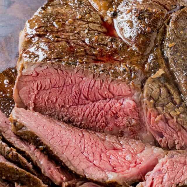 Sliced roast beef resting on a cutting board.