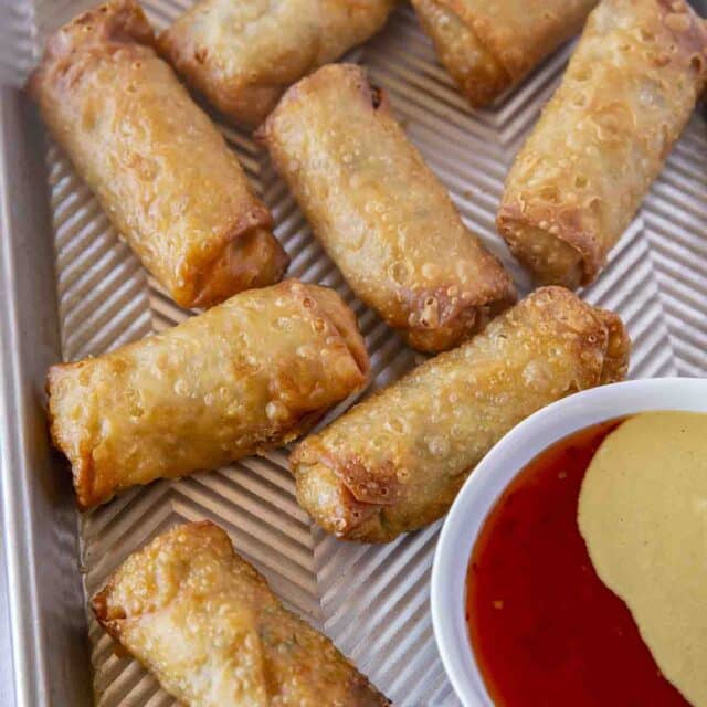 Finished appetizers on a baking dish with sweet and sour sauce