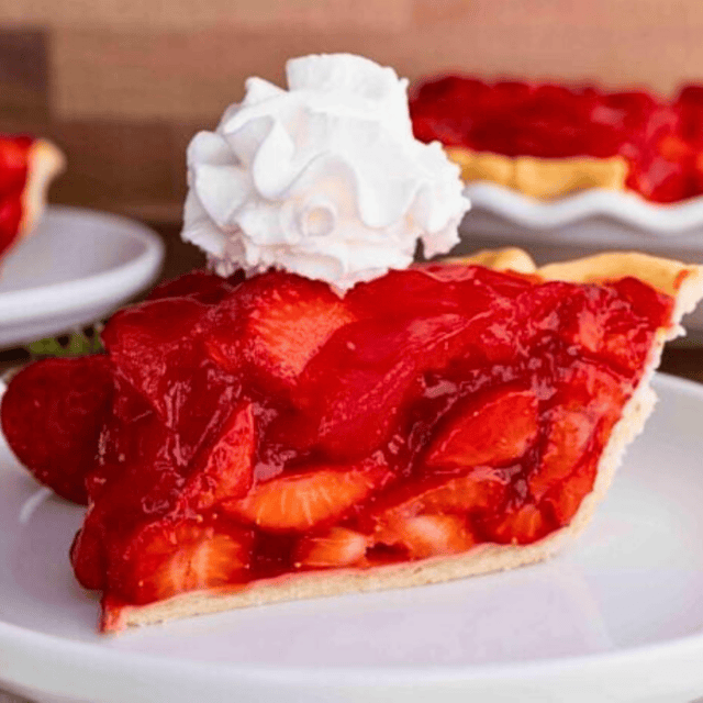 slice of pie on plate with whipped cream topping