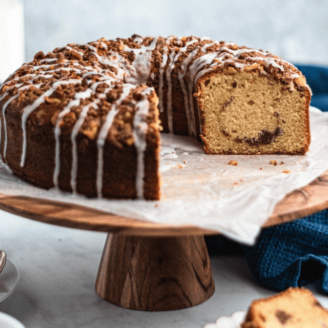 cake on a wooden stand with pieces missing
