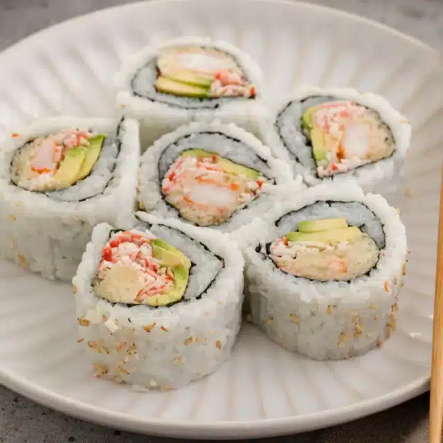 Pieces of sushi on a dinner plate.